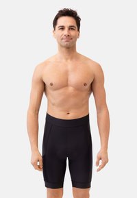 Shorts de cyclisme noirs en tissu extensible, avec une taille haute, une coupe ajustée et une zone rembourrée pour le confort.