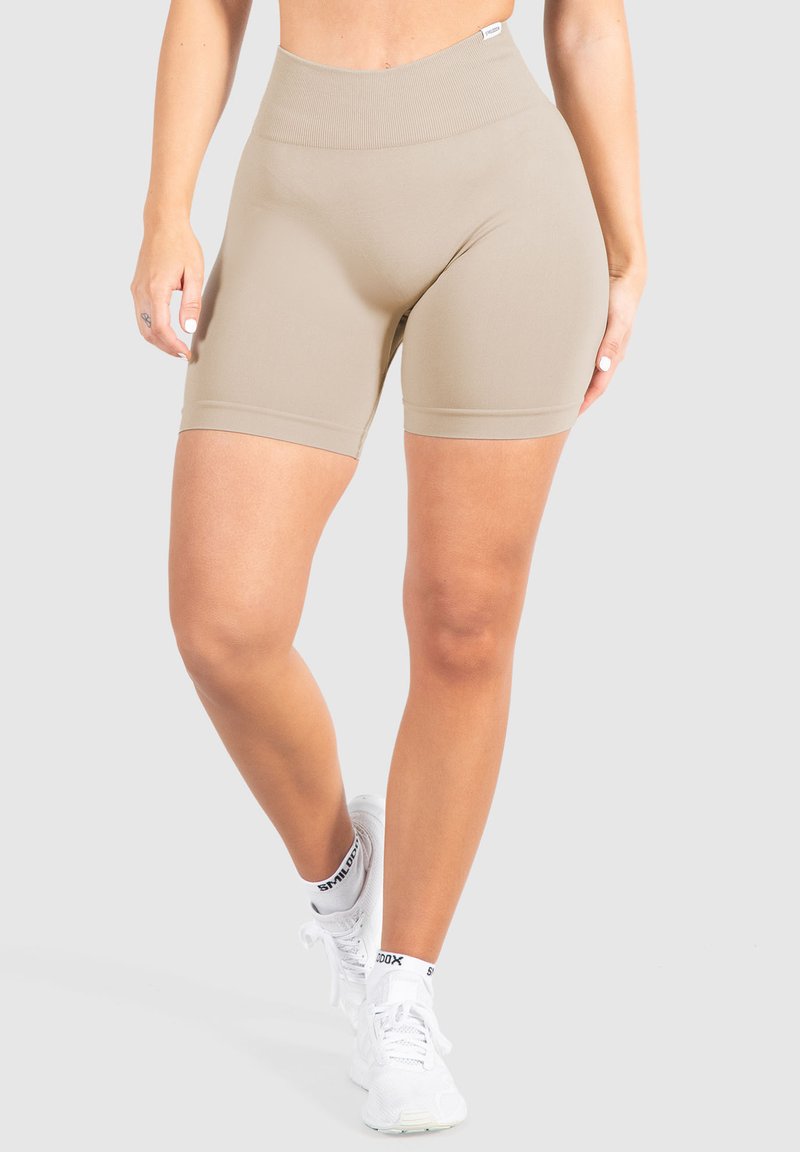 Beige high-waisted fietsshorts van rekbaar materiaal. Heeft een gladde textuur en naadloos ontwerp, eindigend net boven de middel van de dij.
