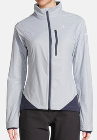 Veste légère grise résistante aux intempéries avec un col montant, des accents bleu marine et une poche poitrine zippée. Texture lisse, coupe ajustée.