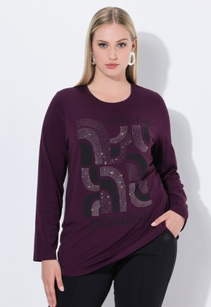 Maglietta a maniche lunghe di colore viola con scollatura rotonda, decorata con testo grafico in cristalli "AMARE IL MOMENTO" in nero e motivi multicolori.