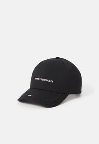 Sort baseball cap lavet af tekstureret stof. Har et frontlogo "TOMMY HILFIGER" i hvidt, med små røde og blå accenter på skyggen.