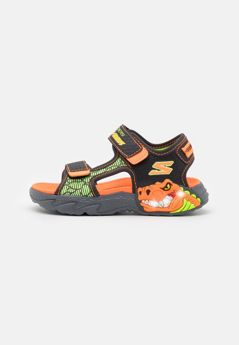 Sorte og grønne sandaler med oransje detaljer, dinosaur-design, justerbare stropper, pustende materiale, strukturert såle for grep.