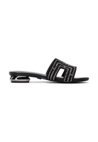 Sandale slide noire avec un petit talon argenté géométrique et un motif géométrique argenté scintillant sur une large bride traversant le pied.