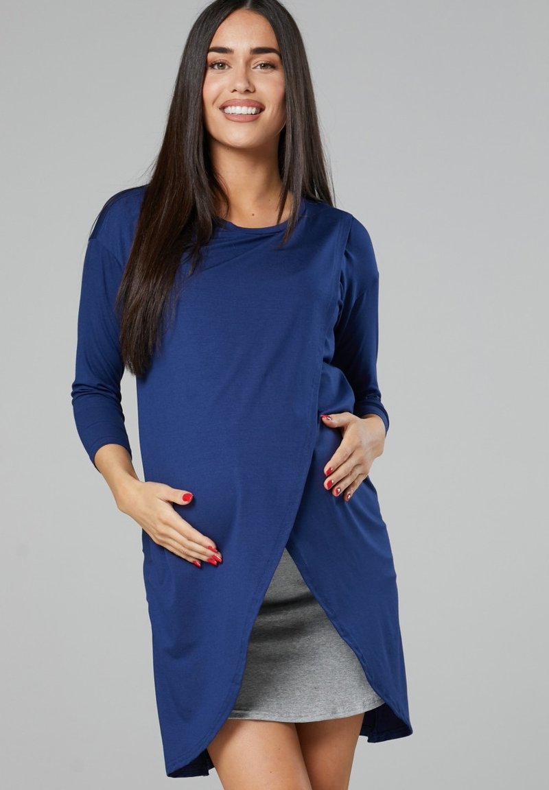 Navy blue long-sleeve dress with a rounded neckline, asymmetrical hem, and loose fit, layered over a gray skirt. Smooth fabric texture.