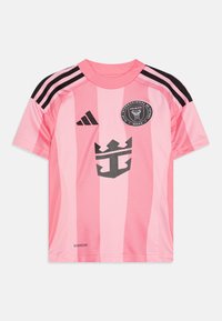 Maglietta sportiva rosa con accenti neri, caratterizzata da strisce verticali, un colletto rotondo e un grande logo nero sul davanti. Realizzata in tessuto traspirante.