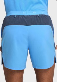 Blaue Sportshorts mit einem dunkelblauen Mesh-Bund, Gittermuster-Akzenten und seitlichen Schlitzen für Bewegungsfreiheit. Leichtes Material.