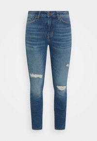 Jeans ajustados en denim azul medio con áreas deslavadas y dos desgastes por encima de las rodillas. Cintura estándar con cierre de botón.