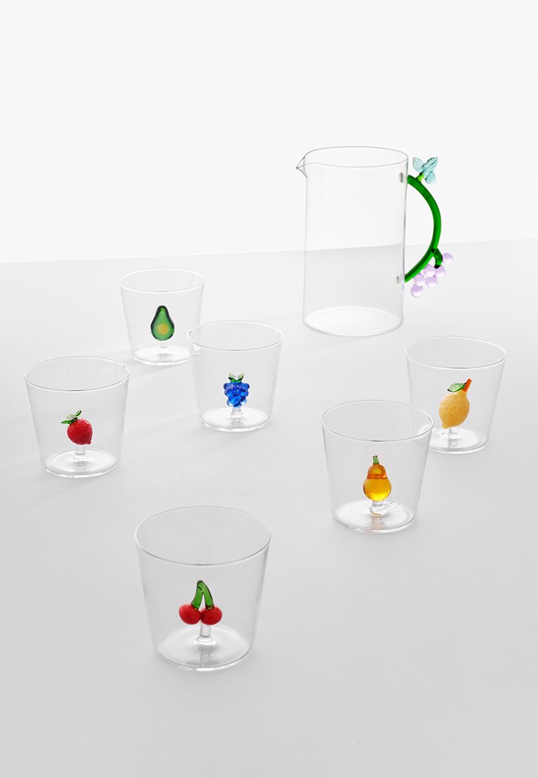 Przezroczysty dzbanek ze szklanym uchwytem w kształcie zielonego winorośli i sześć przezroczystych szklanek, z których każda zawiera dekoracyjną rzeźbę owocu wewnątrz.
