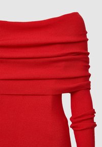 Rotes schulterfreies Kleid mit geripptem Textur; taillierte Oberteile, lange Ärmel mit Raffungen, die zu einem einfachen Saum übergehen.