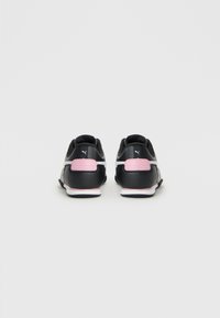 Must have musta ja roosa Puma tossud nähtuna tagant, valgel taustal.