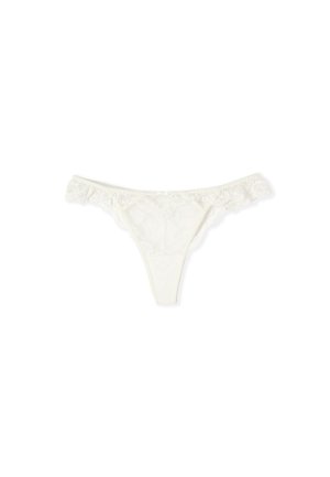 Tanga de encaje blanco con patrones florales y bordes fruncidos sobre un fondo blanco liso.