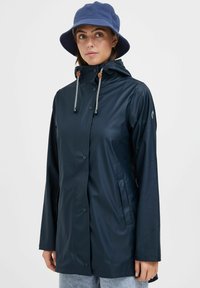 Navy waterproof jacket with a hood, snap buttons, and drawstring details. Smooth texture, featuring side pockets and a relaxed fit.