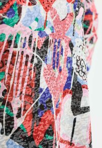 Mehrfarbiger Stoff mit abstrakten Mustern in Pink, Blau und Grün, versehen mit schimmernden Perlen und durchgehend texturierten Details.