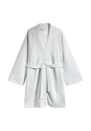 Világosszürke, steppelt köntös hosszú ujjal, nyitott elejű és hozzáillő övvel, amely a deréknál meg van kötve, fehér háttér előtt.