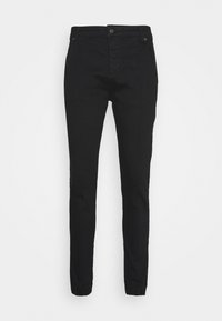 Pantalones negros ajustados de mezcla de algodón; cuentan con un cierre de botón, puños de tobillo elastizados y sutiles detalles en las costuras laterales.
