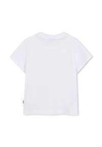 T-shirt bianco in cotone con maniche corte e scollatura a girocollo. Presenta un'etichetta sul lato sinistro. Tessuto liscio, design minimalista.