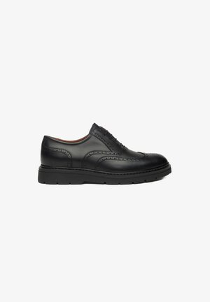 Chaussure habillée en cuir noir avec des détails de brogue, bout arrondi et semelle en caoutchouc noir épais. Dispose de cinq œillets pour les lacets.