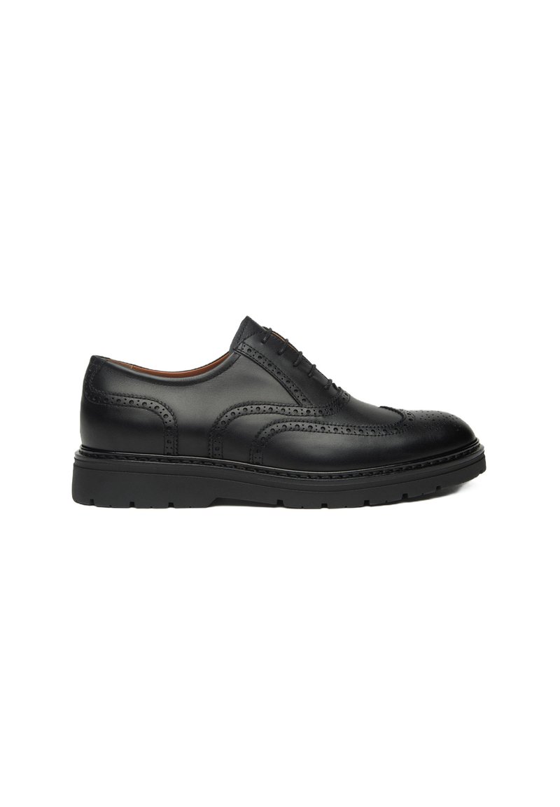 Scarpa da uomo in pelle nera con dettagli brogue, punta tondeggiante e suola spessa in gomma nera. Presenta cinque occhielli per i lacci.