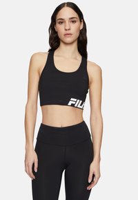 Czarny crop top z dekoltem w serek oraz białym logo Fila po lewej stronie. Materiał wydaje się gładki, a krój jest dopasowany.