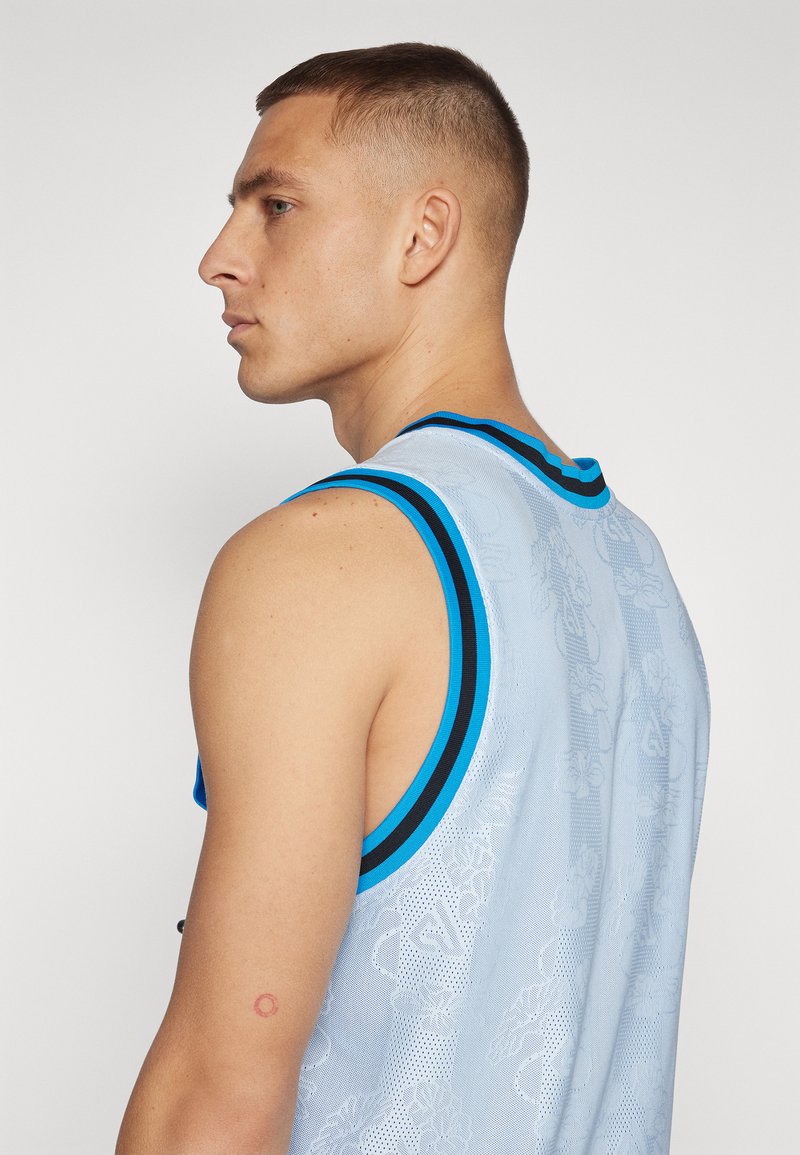 Débardeur de sport en mesh bleu clair avec un motif floral texturé et des accents noir/bleu au niveau de l'encolure et des emmanchures.