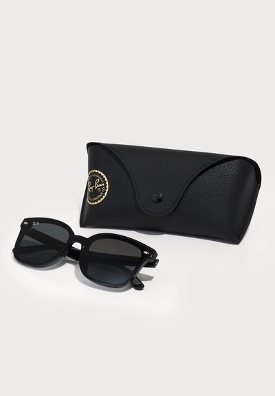 Черни слънчеви очила Ray-Ban с квадратни рамки, сиви лещи и сребърни детайли. С придружаваща черна текстурирана кутия с лого.