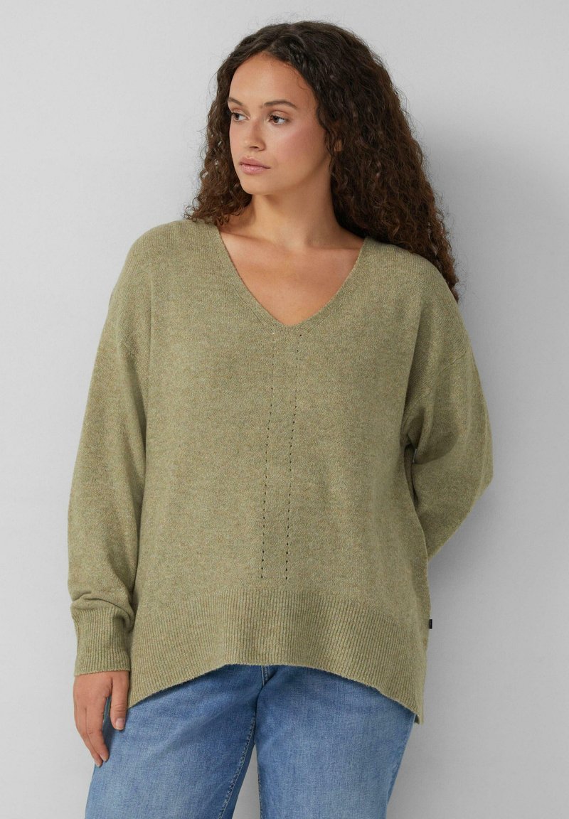 Olijfgroen, gebreid sweater met een V-hals en geribbelde manchetten. Kenmerkt zich door een geperforeerd patroon in het midden en een iets langere achterzoom.