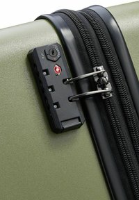 Maleta rígida verde con cremallera negra, candado de combinación y seguridad aprobada por la TSA. Textura lisa con un acabado mate.