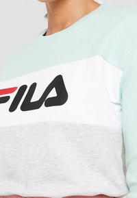Sudadera bloqueada en color verde menta, blanco y gris con el logo en negro de "FILA", cuello redondeado y puños acanalados. Material suave de mezcla de algodón.