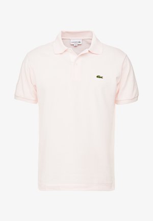 Koszulka polo w jasnoróżowym kolorze, wykonana z bawełny, z klasycznym kołnierzykiem, krótkimi rękawami oraz zielonym haftowanym logo Lacoste po lewej stronie klatki piersiowej.