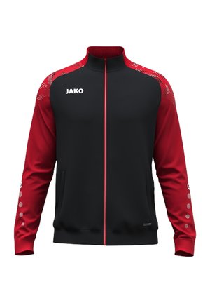 Træningsjakke med sort front og torso, røde ærmer med prikkemønster, rød lynlås, høj krave og hvidt "JAKO" logo på brystet.