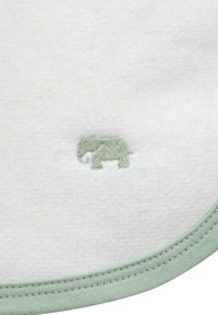 Bílá látka má na sobě světle zelenou vyšívanou logo slona, hladký povrch a zaoblený okraj v odpovídající zelené barvě.