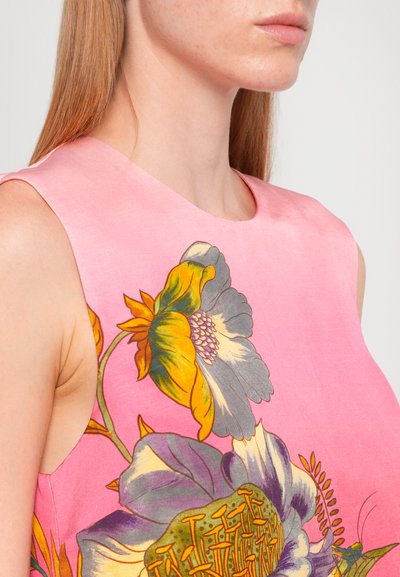 Floral dress featuring a bright pink fabric with large yellow and gray flowers, smooth texture, and a sleeveless design with a rounded neckline.