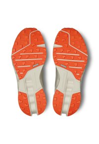 Plantas de zapatos con una base de color beige claro y una suela de color naranja brillante. Presenta un patrón texturizado con formas variadas para mejorar la tracción.