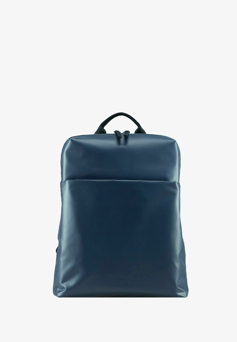 Mochila azul marino hecha de un material brillante y suave con forma rectangular. Cuenta con un cierre de doble cremallera y un bolsillo frontal para almacenamiento.