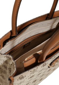 Brown patterned handbag with tan leather accents, featuring two top handles, spacious lined interior, and a zippered compartment for security.