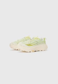 Chaussures de sport vert léger avec une tige en mesh respirant, un col rembourré et une semelle blanche épaisse. Comprend des accents réfléchissants et une texture antidérapante.