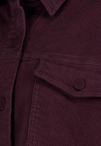 Corduroy fabric in deep burgundy color with prominent vertical ridges. Features a pointed collar and two flap pockets with round buttons.