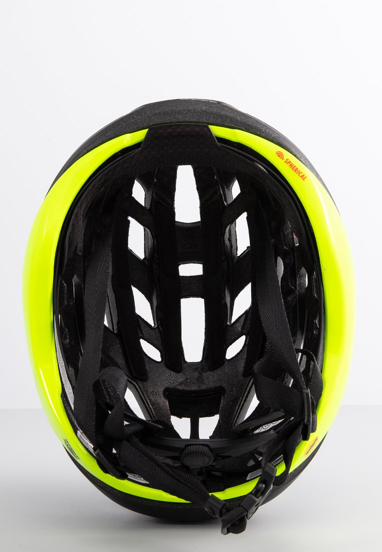 Jasně žlutá a černá cyklistická helma pohledem z vnitřku, viditelné větrací otvory, nastavitelné popruhy a výstelka.