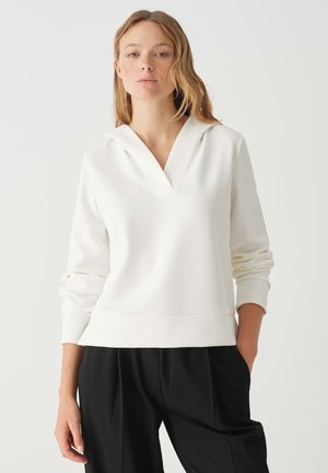 Weißer Sweater mit V-Ausschnitt und Kapuze, ausgestattet mit langen Ärmeln und einem gerippten Saum. Das Material wirkt weich und glatt und hat eine entspannte Passform.