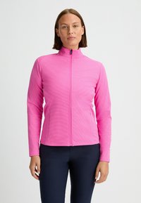 Tight-fittad rosa zip-up-jacka med en strukturerad yta, hög krage och sidofickor. Materialet verkar vara elastiskt och lättviktigt.