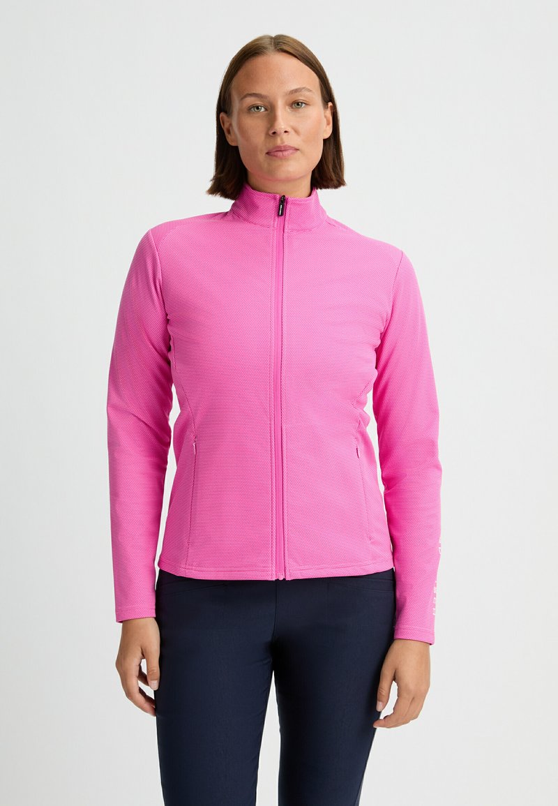 Tight-fittad rosa zip-up-jacka med en strukturerad yta, hög krage och sidofickor. Materialet verkar vara elastiskt och lättviktigt.