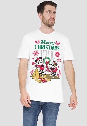 White t-shirt featuring a printed holiday scene with Mickey and Minnie Mouse, and Pluto, surrounded by Christmas decorations and text.