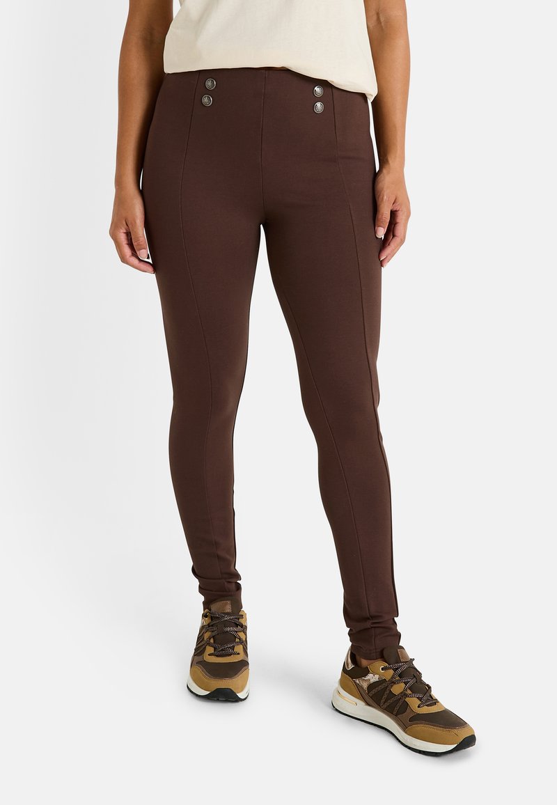 Leggings ajustados marrones con una textura suave, que cuentan con dos botones decorativos en la cintura y costuras en contraste a lo largo de los lados.