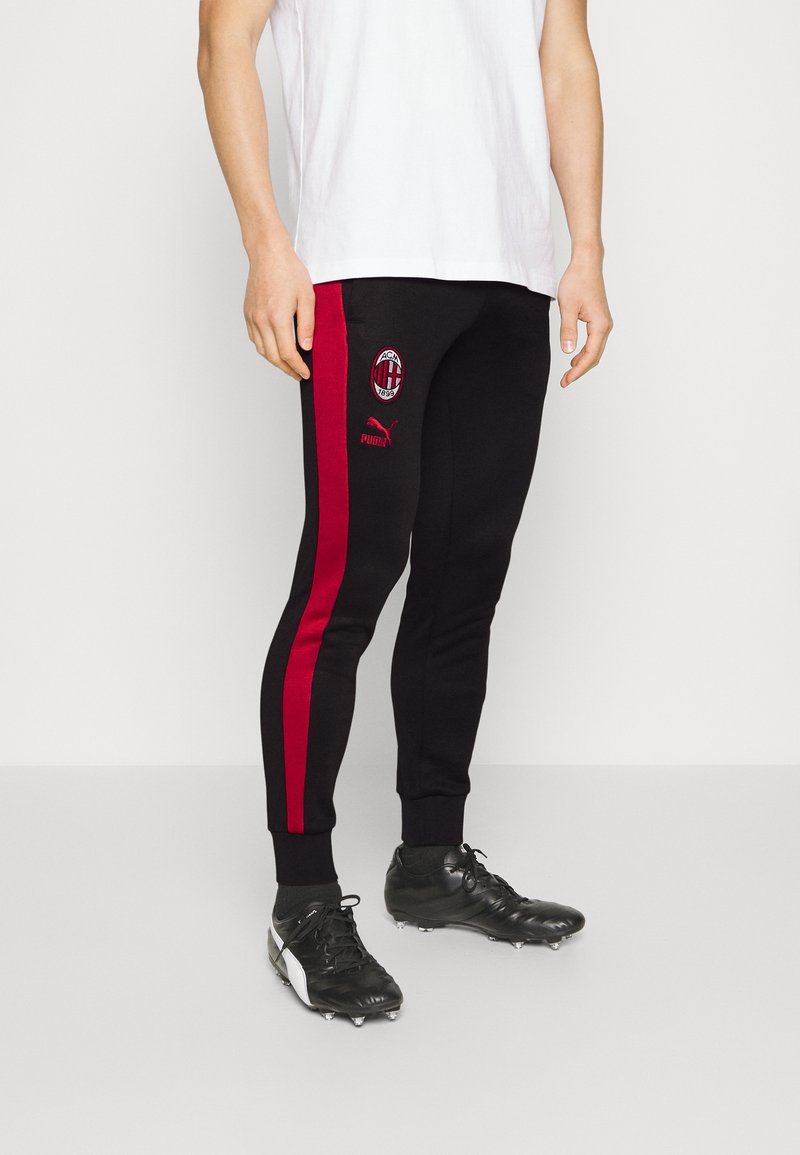 Schwarze Sweatpants mit roten Seitenstreifen, ausgestattet mit dem AC Milan-Logo und Puma-Branding. Hergestellt aus weichem Stoff, eng an den Knöcheln.