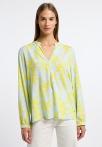 Langärmlige Bluse in Hellblau und Gelb mit einem abstrakten Blumenmuster, V-Ausschnitt und dezenter Knopfdetaillierung an den Ärmelbündchen.