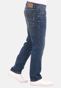 Jeans in denim di colore blu scuro con taglio dritto, dotati di due tasche posteriori, etichetta del brand e dettagli di cucitura visibili.