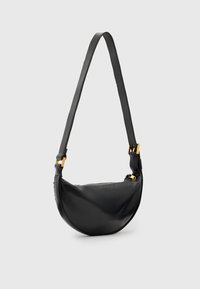 Svart läderaxelväska med en böjd form, justerbar rem och detaljer i guldton. Slät textur, minimalistisk design.