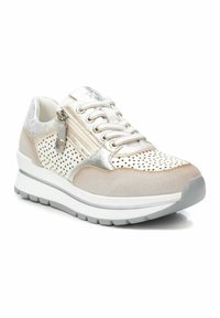 Baskets beige clair avec un design perforé, des accents métalliques et une fermeture éclair. Dispose d'une semelle blanche rembourrée avec un profilé gris.