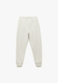 Lysegrå sweatpants lavet af blødt stof, med elastisk talje, manchetter og lige ben. Glat tekstur uden synlige mønstre.