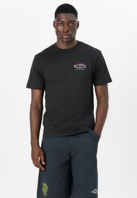 Zwarte katoenen T-shirt met een ronde hals en korte mouwen. Heeft een klein, veelkleurig "Billabong" logo op de borst.